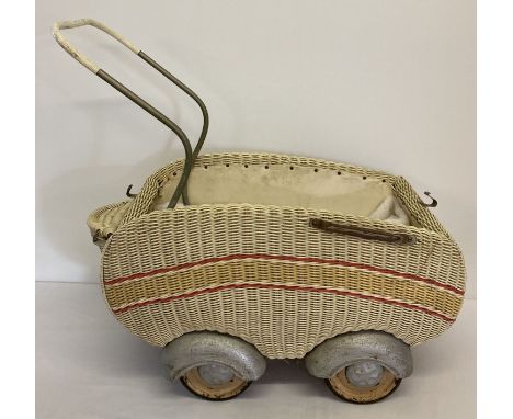 A vintage plastic coated woven basket style dolls pram with tinplate wheels and rubber tyres.   Height to handle bar approx. 