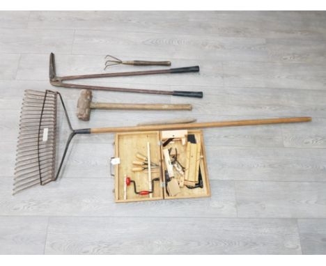 An Elwell lawn comb, sledgehammer and other tools.
