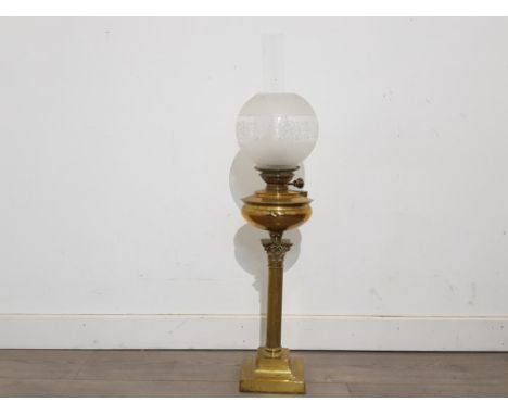 A Victorian brass oil lamp with glass shade, supported on corinthian column 53cm high excluding shade.