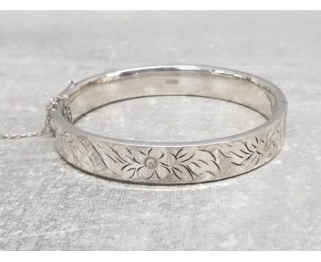 A silver bangle with engraved floral decoration, 16g.