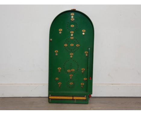 A Chad Valley bagatelle board, with four marbles.
