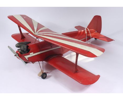 A scale model of a biplane wearing the livery of a Pitts Special aeronautical plane in red and white with ASP two stroke engi