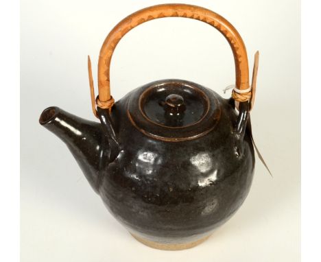 A Leach globular tenmoku glazed teapot with cane handle.  Pottery seal and indistinct Japanese personal seal, possibly Shigey