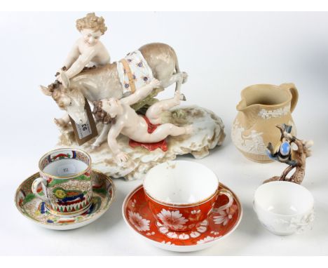 A continental porcelain group, a Victorian saltglaze jug, Spode cup and saucer, a porcelain coffee can and saucer, a Derby te