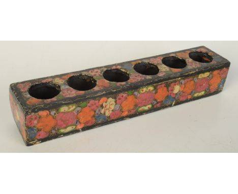 A Persian black lacquered and floral decorated hat finial stand, height 3.7cm, length 21.4cm, depth 4cm.