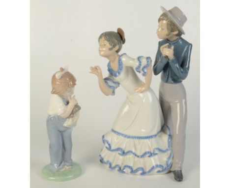 A Nao by Lladro group of a dancing couple, height 27cm and another Nao figure of a young girl with a doll, height 18cm.