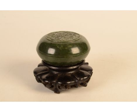 A Chinese spinach green jade squat shaped rounded bowl and cover, the latter carved in low relief with a medallion within whi