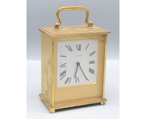 A Jaeger Le Coultre brass mantel clock, the rectangular silvered dial with arabic numerals, on bun feet, height 13cm, width 1