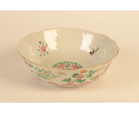 A Chinese petal rimmed bowl decorated in the famille rose palette, decorated with alternating sprays of peony, iris and lotus