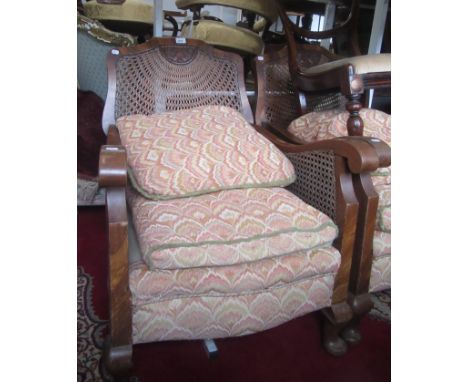 An Art Deco walnut three piece bergere suite, comprising of a three seater sofa and a pair of matching armchairs, each with a