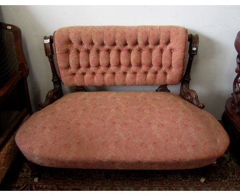 A Victorian walnut sofa, with a button upholstered padded back flanked by fluted and turned columns, acanthus leaf scroll arm