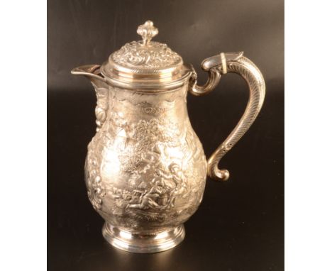 A silver coloured metal jug and cover the pair shaped body richly repousse decorated with wild boar and hunting dog on one si