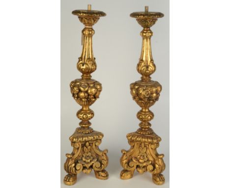 A pair of gilt moulded candlesticks with tripod bases in 18th century European style.