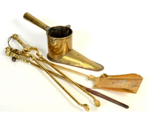 A set of three brass fire irons, a fireguard and a brass ale warmer crested with an acorn over the initials A.E.O.