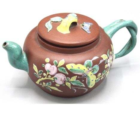 A Chinese Yixing teapot, enamelled to the exterior with a butterfly amongst foliage, impressed seal mark, height 10cm, width 