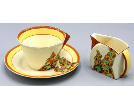 A Clarice Cliff 'Sunshine' pattern Stamford shaped cream jug, height 6.3cm, width 8.5cm and a cup and saucer.   Condition rep