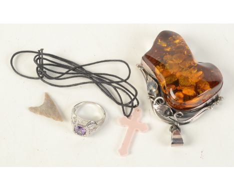 A stone set ring, a stone arrow head, a simulated amber pendant and a cross. 