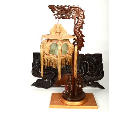 A Chinese hardwood table lamp, early 20th century, in the form of a stylised dragon, height 67cm and a Chinese carved wood pa