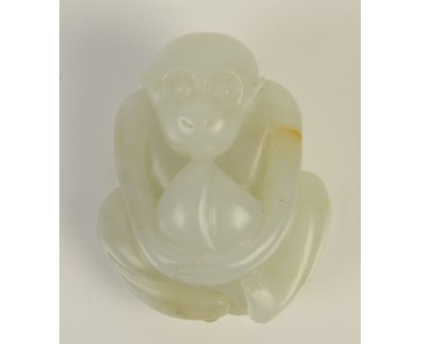 A Chinese mutton fat jade pebble carved as a squatting monkey holding a large peach, depicting the tale of it stealing the pe