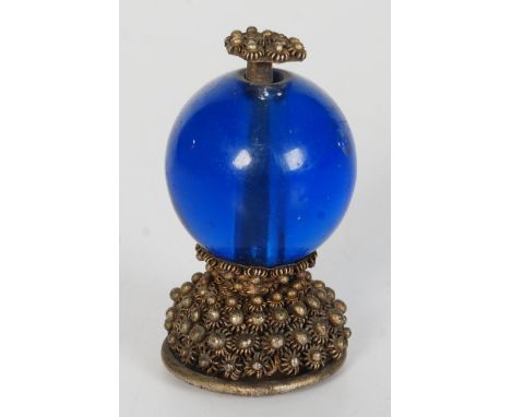 A Chinese metal and blue glass hat finial, 19th century, floral decorated mounts, height 5.5cm.   Condition report:  Some bru