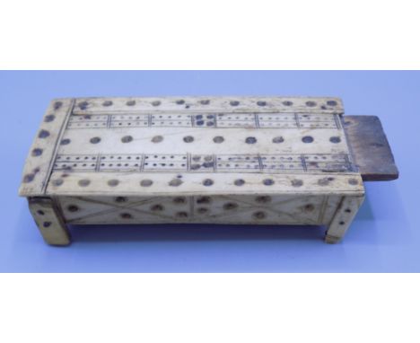 A Napoleonic French prisoner of war bone and wood cribbage board, early 19th century, with a sliding cover on square section 