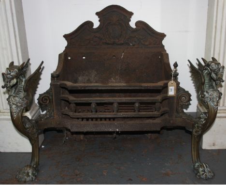 A Victorian brass and cast iron fire grate basket, flanked by models of griffins, height 63cm, width 81cm.