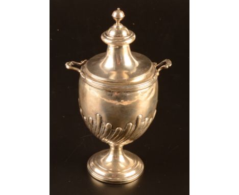 A George IV tea caddy of urn form, the lid with ball finial, the flat shoulder with twin handles the body gadrooned instinct 