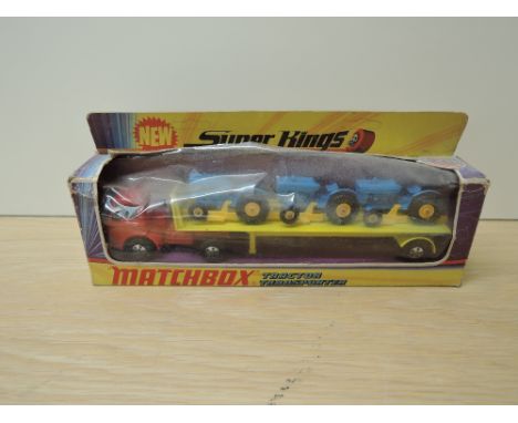 A 1971 Matchbox Super Kings diecasts, K20 Tractor Transporter in yellow and red with three Tractors in blue with yellow hubs,