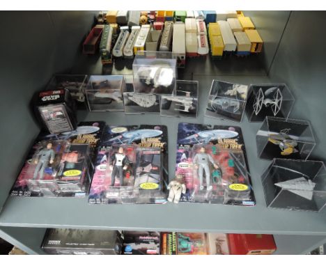 A shelf of modern Star Trek and Star Wars figures and accessories, all boxed or on bubble cards (12)