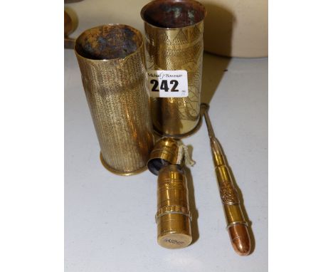 A WWI trench art shell lighter, a button hook and two small engraved shell cases. (4)