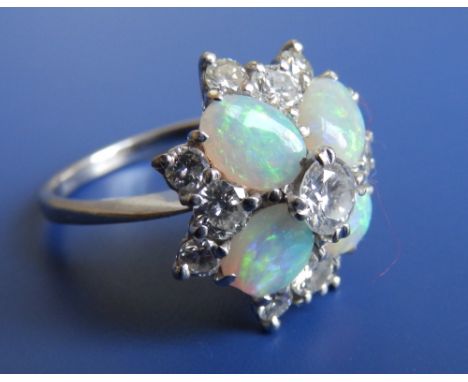 A modern opal & diamond cluster ring, the central brilliant cut diamond weighing approximately 0.40 carat on 18ct white metal