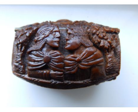 A 19thC French coquilla nut snuff box, the hinged cover and base each carved with busts of two classical male figures, 2” acr