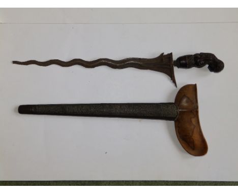 A 19thC kris, the pommel carved as a figure of Rashka in wood & metal scabbard, 19” overall – blade tip broken.