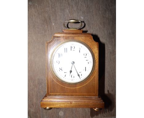 A small mahogany mantel clock with convex enamel dial.