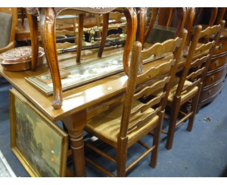 AN OAK DINING TABLE, and four oak framed ladder back rush seated chairs (5)