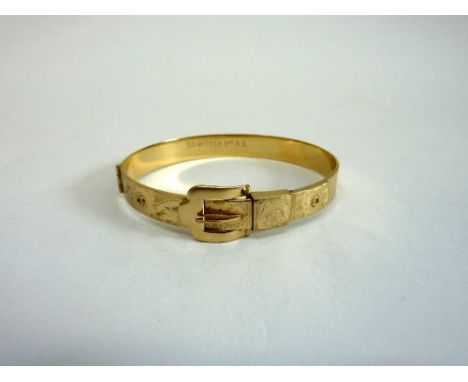 A 9CT ROLLED GOLD BUCKLE BANGLE, the buckle forming the clasp with engraved flowers to the sides, inner diameter 6cm