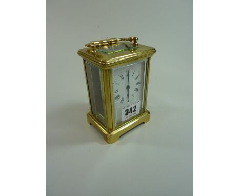 A BRASS FOUR PANE CARRIAGE CLOCK, with enamelled dial, 11cm excluding handle