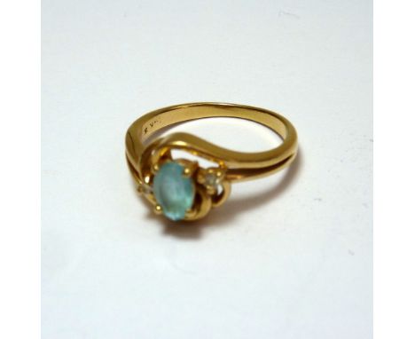 A TOPAZ AND DIAMOND RING, the oval shape aquamarine, flanked by brilliant cut diamonds within an abstract twisting shank, hal