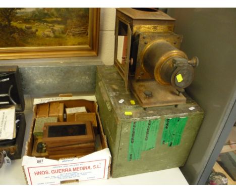 A TINPLATE AND BRASS MAGIC LANTERN, with original fitted case, together with a collection of slides including moving cartoon 