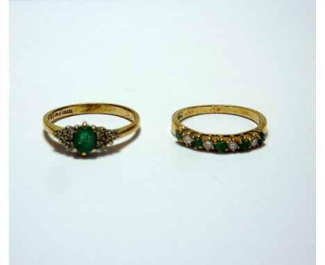 TWO 9CT GOLD EMERALD AND DIAMOND RINGS, the first designed as an emerald and diamond band, the second an oval shape emerald w