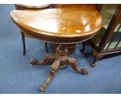 A 19TH CENTURY WALNUT DEMI LUNE FOLD OVER CARD TABLE, with green baize playing surface on carved support