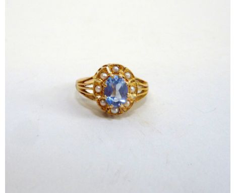 A 9CT GOLD TOPAZ AND PEARL RING, the oval shape topaz within a surround of seed pearls to the tapered band, hallmarks for Bir