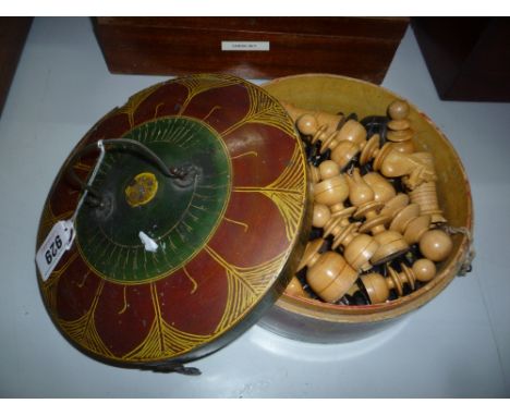 A TURNED BOXWOOD CHESS SET, ebonised and natural, in painted circular box