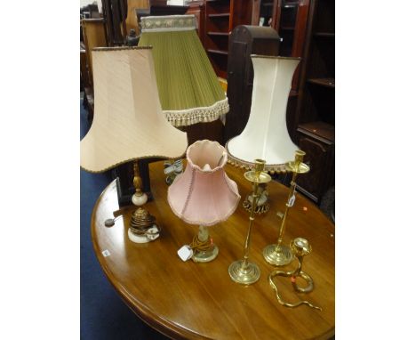A PAIR OF BRASS CANDLESTICKS, another brass candlestick and four table lamps with shades (6)