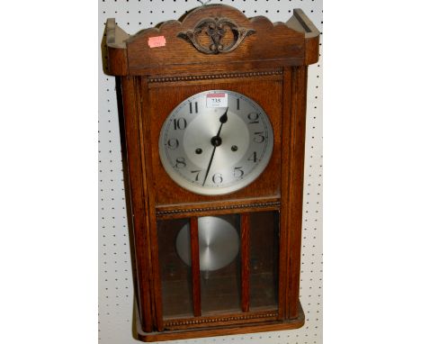 A 1930s oak drop trunk wall clock