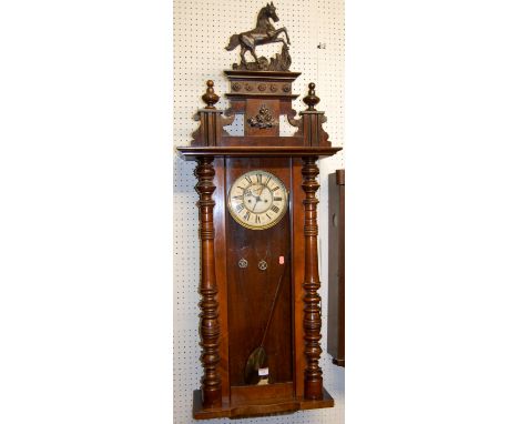 An early 20th century walnut Vienna drop trunk wall clock having twin weight driven striking movement