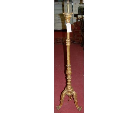 An early 20th century carved giltwood standard lamp having floral and fluted column over acanthus leaf carved supports