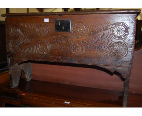 A circa 1700 boarded oak hinge-top six plank coffer, having line carved front panel 