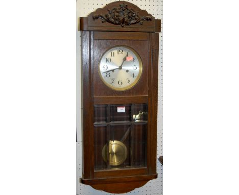 A 1930s oak drop trunk wall clock
