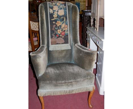 An early 20th century walnut framed and part-floral tapestry upholstered wingback armchair 